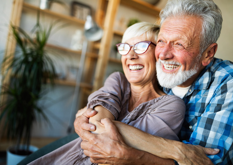 Coppia di signori che sorride abbracciandosi